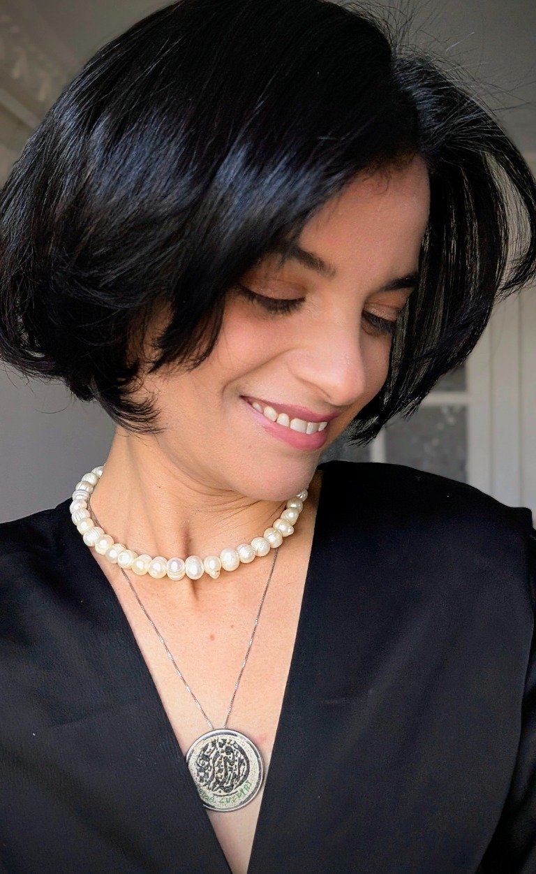 Artist Emna Guediri wearing her contemporary micro-mosaic pendant